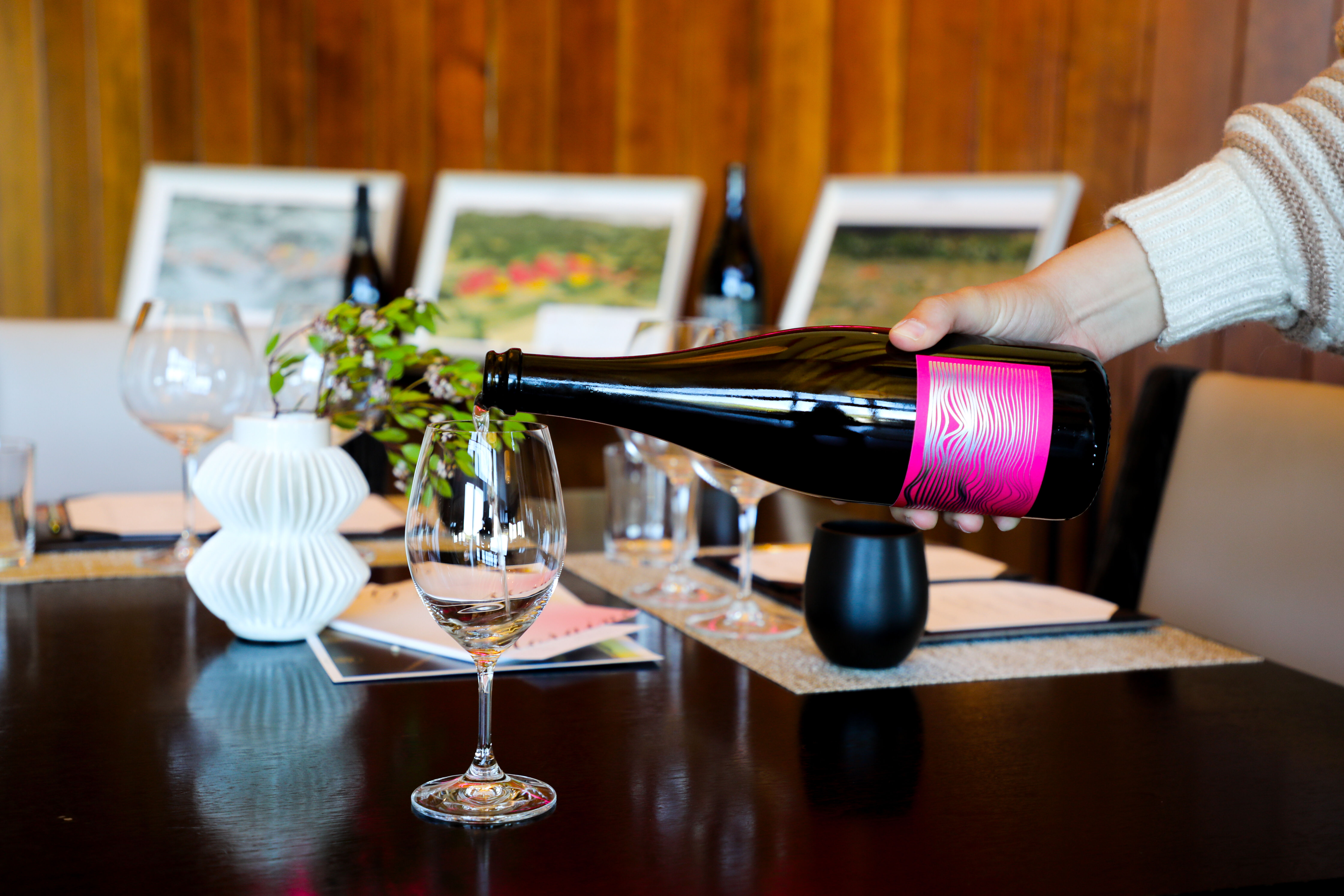 Man serving white wine behind a wine tasting bar